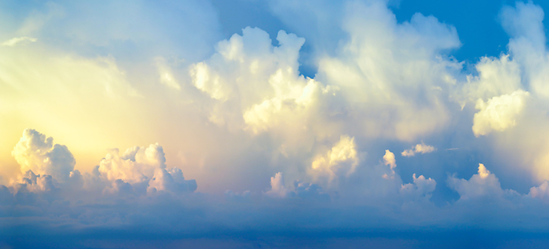 Sunlight breaking through clouds in a blue sky